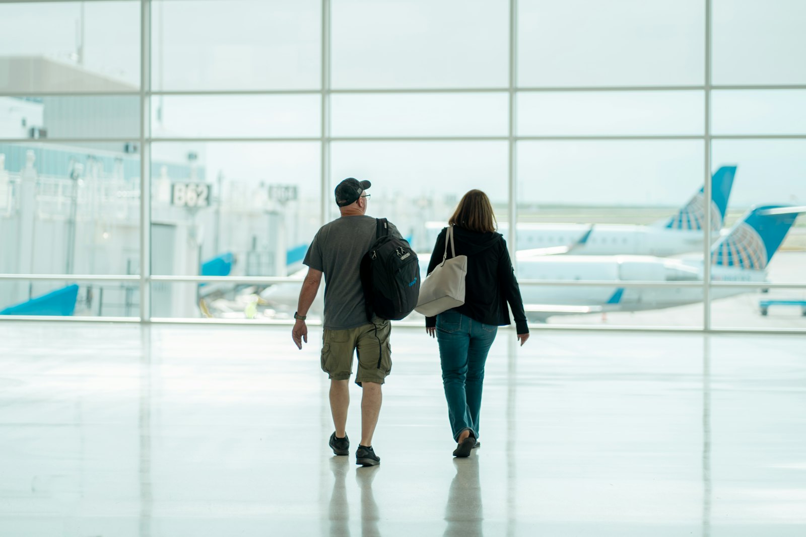 Two travellers walking towards their departure gate