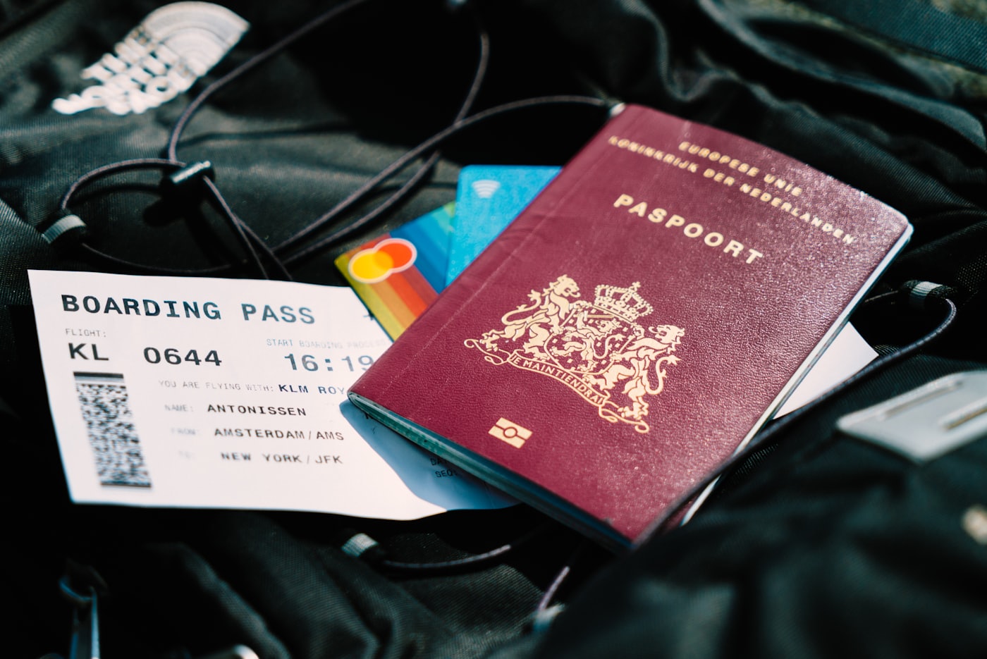 A boarding pass and passport resting on a travel bag